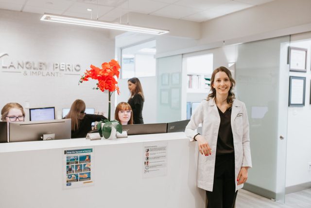dentist smiling in front of our front desk