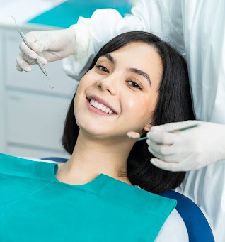 woman smiling as dental holds dental tools
